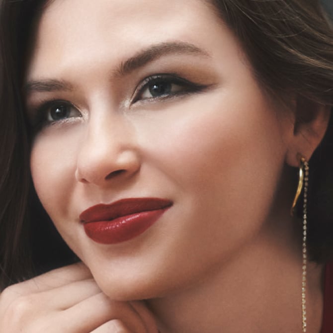 Model applying Skin Long-Wear Weightless Foundation to skin with a foundation brush