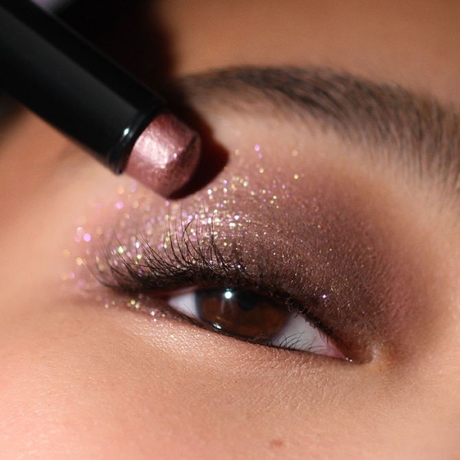 Close up of model eye showcasing defined brows and a natural, shimmery eye look