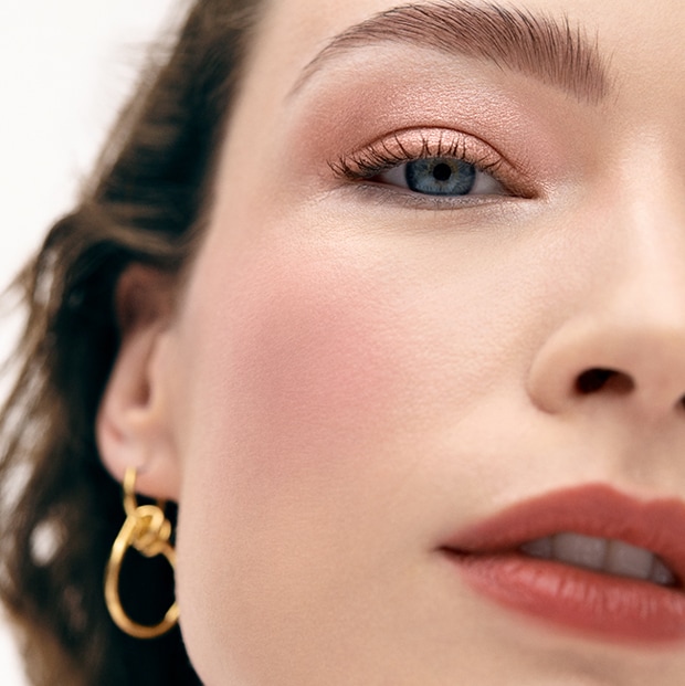Model applying Skin Long-Wear Weightless Foundation to skin with a foundation brush